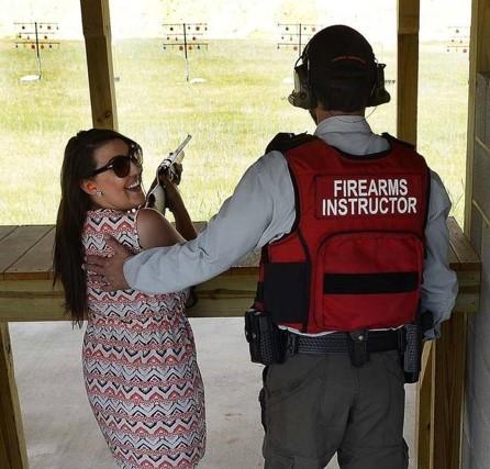 Shooting instructor teaching woman to shoot a rifle